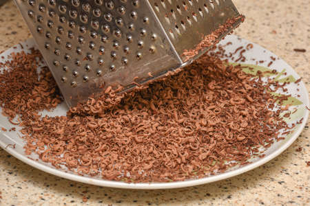 Broken crumbs of delicious sweet milk chocolate during the preparation of desserts, details of...