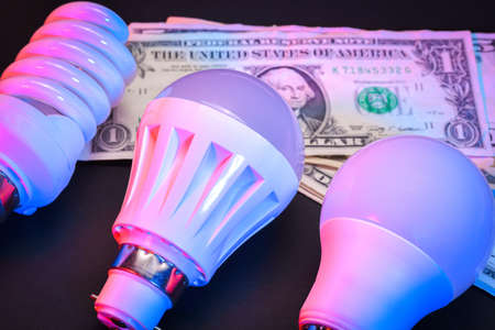 The concept of LED bulbs with banknotes of dollars as electricity costsの写真素材