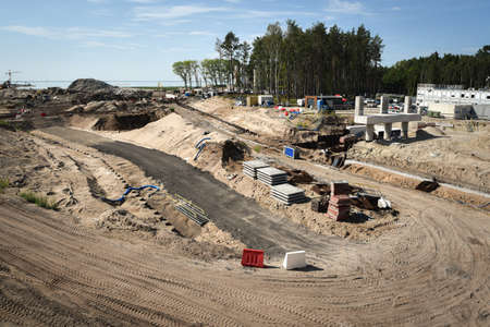 Machines working on a building site and elements stored on a construction site during work in...