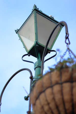 Old green street light lantern with hanging basketの写真素材