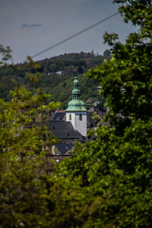 Church tower looks out between the treesの写真素材