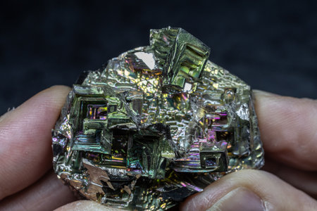 Scientist examines iridescent bismuth crystals in close-up