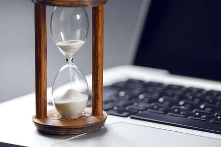 Hourglass as time passing concept for business studying deadline, urgency and running out of time.