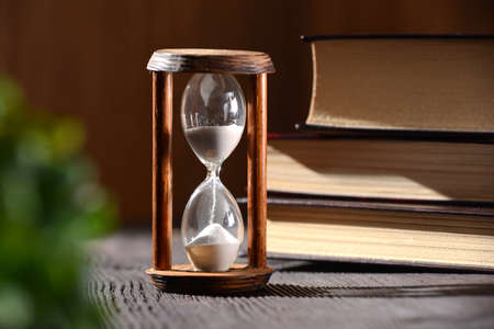 Hourglass as time passing concept for studying deadline, urgency and running out of time.の写真素材