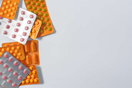 Pile of colorful tablets and capsules pills in blister packs. Global health care and drug use with reasonable conceptの写真素材