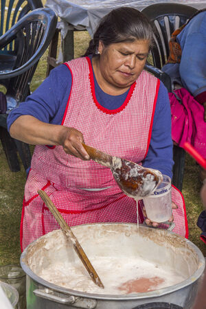 Yucay, Peru - July 25, 2013  woman serving a glass of chichaのeditorial素材