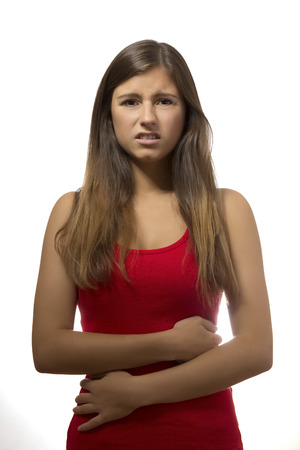 one beautiful teenage girl portrait with stomach ache in white backgroundの写真素材
