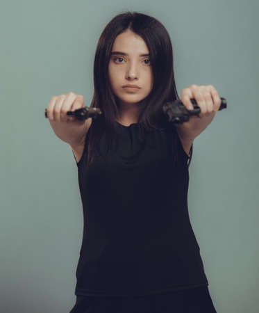 Shot of a military woman posing with gunsの写真素材