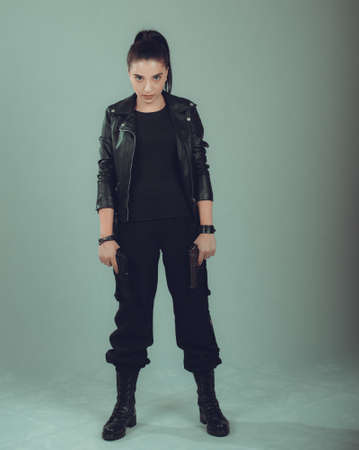 Shot of a  military woman posing with guns,in a black jacket