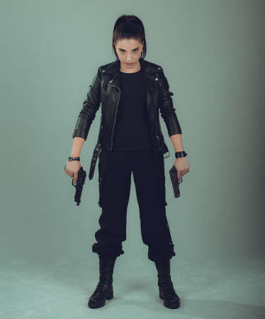 Shot of a  military woman posing with guns,in a black jacket