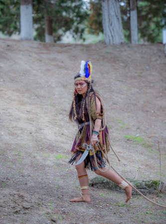 Native American indian woman portrait outdoors,portrait of shamanic female with Indian feather hat...