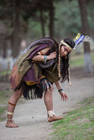 Native American indian woman portrait outdoors,portrait of shamanic female with Indian feather hat and colorful makeup,の写真素材
