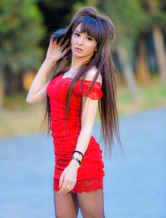 Amazing luxury woman in stylish red party dress posing on outdoor,