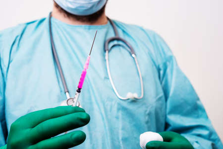 doctor with injcetion stethoscope and maskの写真素材