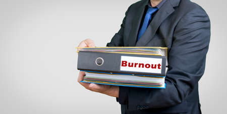 a businessman with folders an burnout textの写真素材