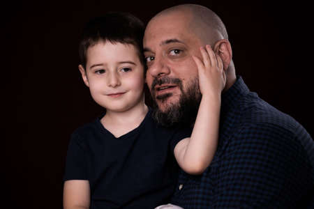 Portrait bearded father and son on black backgroundの写真素材