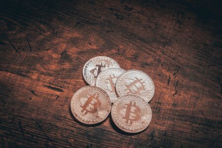 Golden bitcoins on a dark wood background. Bitcoin is a convention payment in a global economy...