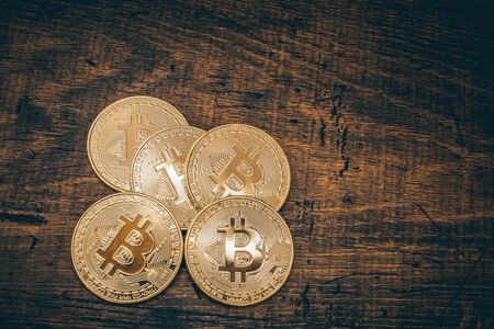 Golden bitcoins on a dark wood background. Bitcoin is a convention payment in a global economy...