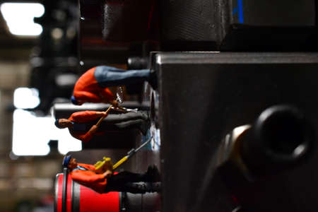 Miniature Workers on Sheet Metal Stamping Tool Die for Automotive Precision Parts on the Numerical Control Milling Machine Table. Tandem Stamping System. At a High Quality Technology Factory.の写真素材