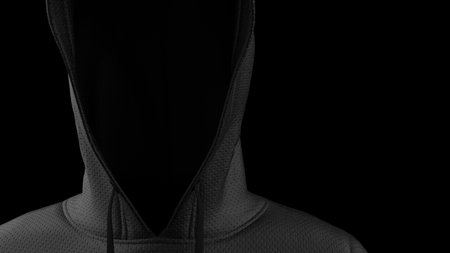 Anonimous hacker with black hoodie in shadow under spot lighting background. Dangorous criminal...