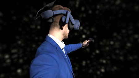Businessman in elegant blue suit with VR headset and controller taking part in virtual conference...