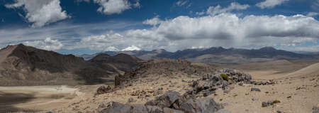 Sajama National Park surrounded by snow-capped mountains with wite clouds and sunshine surrounded by...