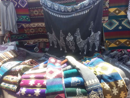 Colorful patterned shawls and scarves at the street market. sale of scarves. Banos Ecuador