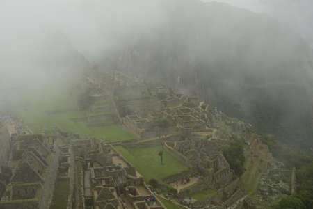 Ruins of the ancient Inca city machu picchu in fog, Peru.の写真素材