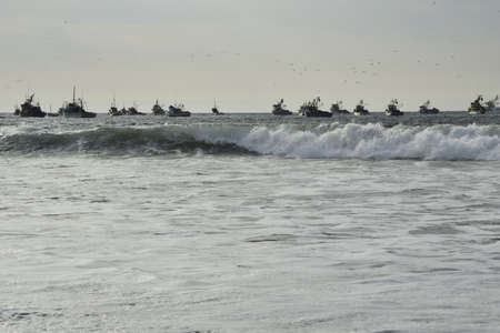 sunset over mancora beach with fisher boats, peru.の写真素材