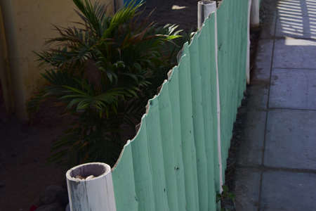 A green fence made of bamboo trunks. Mancora, Peru.