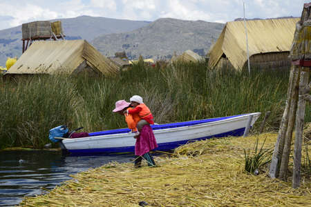 Floating islands near Puno city, Buildings and houses made of straw on the floating islands of Lake Titicaca. Puno, Peru.の写真素材