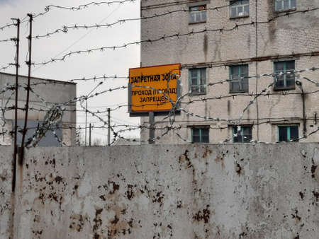 restricted area, passage is prohibited (closed), entry is prohibited or prohibited sign behind metal gates with barbed wire, in Russian.の写真素材