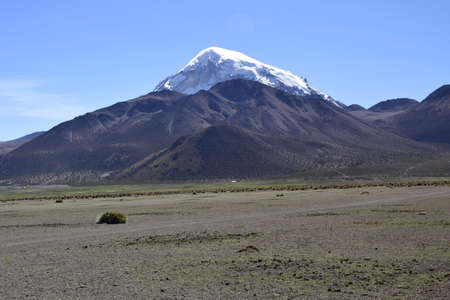 Sajama National Park surrounded by snow-capped mountains in the rainy season with black clouds and...