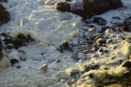 Sea foam among the rocks on the ocean coast. Antofagasta, Chile
