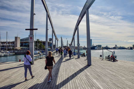 Barcelona, Spain - 3 October 2019: People are passing port vell on la rambla del mar bridge in Barcelona, Spainのeditorial素材
