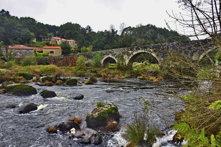 Old stone bridge with arches across the river. The Way of St. James, Northern Route, Spain