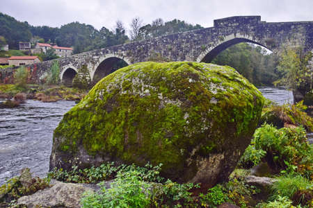 Old stone bridge with arches across the river. The Way of St. James, Northern Route, Spain