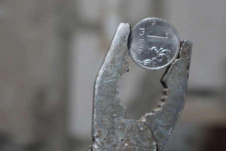 Coin one Russian ruble clamped in a pliers