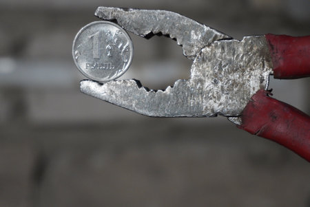 Coin one Russian ruble clamped in a pliersの写真素材