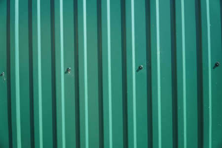 A fragment of a wall made of green metal sidingの写真素材