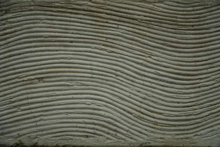 Wavy lines as an ornament from plaster on the outer facade in beige color can also be used as a...