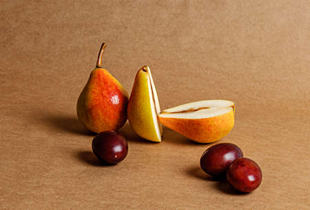 assorted fruits, two pears and plums on craft paperの写真素材