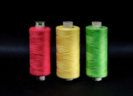 three colored coils pink yellow green on black background