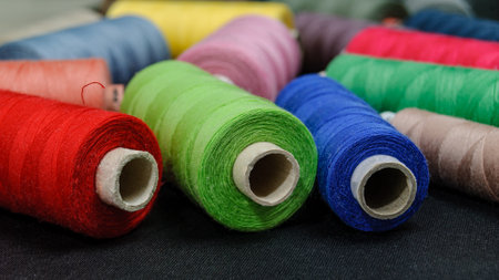 colorful spools of thread on black background