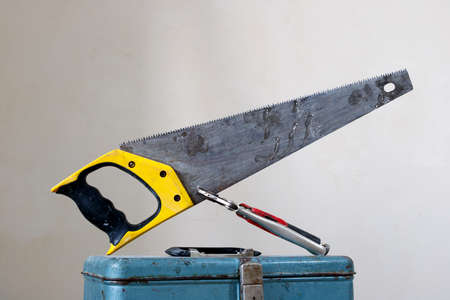 the saw, standing on the toolbox, is clamped by a clampの写真素材