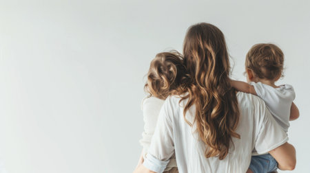 A woman is seen holding a child in her arms. The womans arms are wrapped securely around the child, who seems to be looking up at her. Both individuals appear relaxed and content in each others presence.の素材