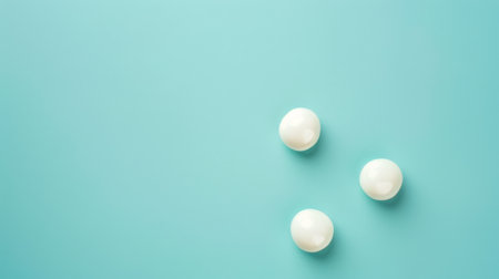 Three white pills are arranged neatly on a bright blue background, creating a simple and clean composition. The pills are round and smooth, with a glossy finish.の素材