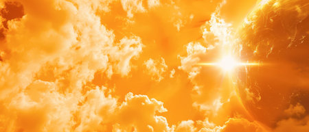 A bright, shining sun rises above white puffy clouds in a brilliant orange sky. The sun's rays emanate outward, illuminating the clouds and creating a warm, inviting atmosphere.の素材