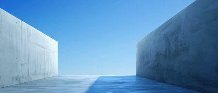 A perspective shot of two smooth, grey concrete walls meeting in the middle to form a pathway. The walls stand tall against a bright, cloudless blue sky. The ground is a smooth, light grey concrete surface with a slight sheen, reflecting the blue of the sky.の素材