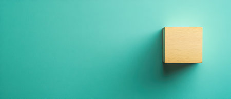 A simple wooden block rests against a smooth turquoise surface illuminated by soft lighting showcasing its texture and color.の素材